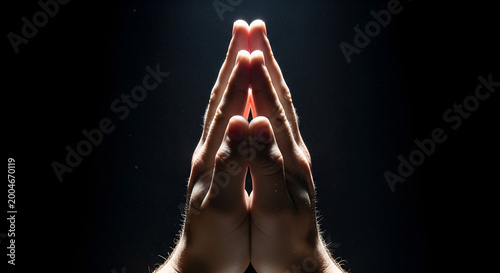 Praying hands clasped in worship against dark background, dramatic rim lighting, spiritual devotion, faith, meditation, religious prayer, divine light, hope, peaceful mindfulness.