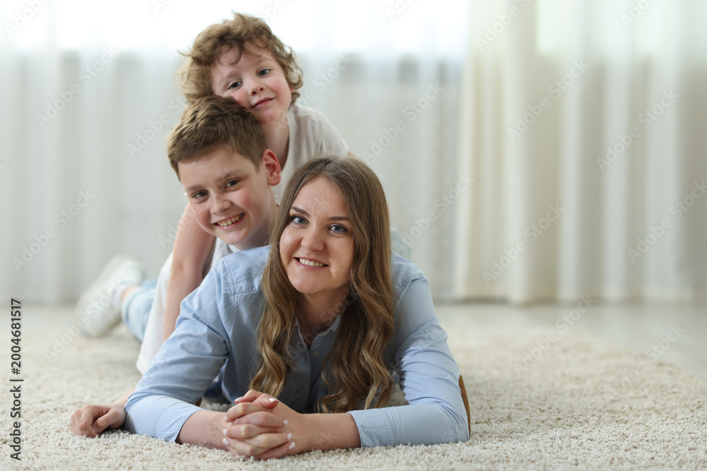 Fototapeta premium Portrait of mother and her sons at home, space for text