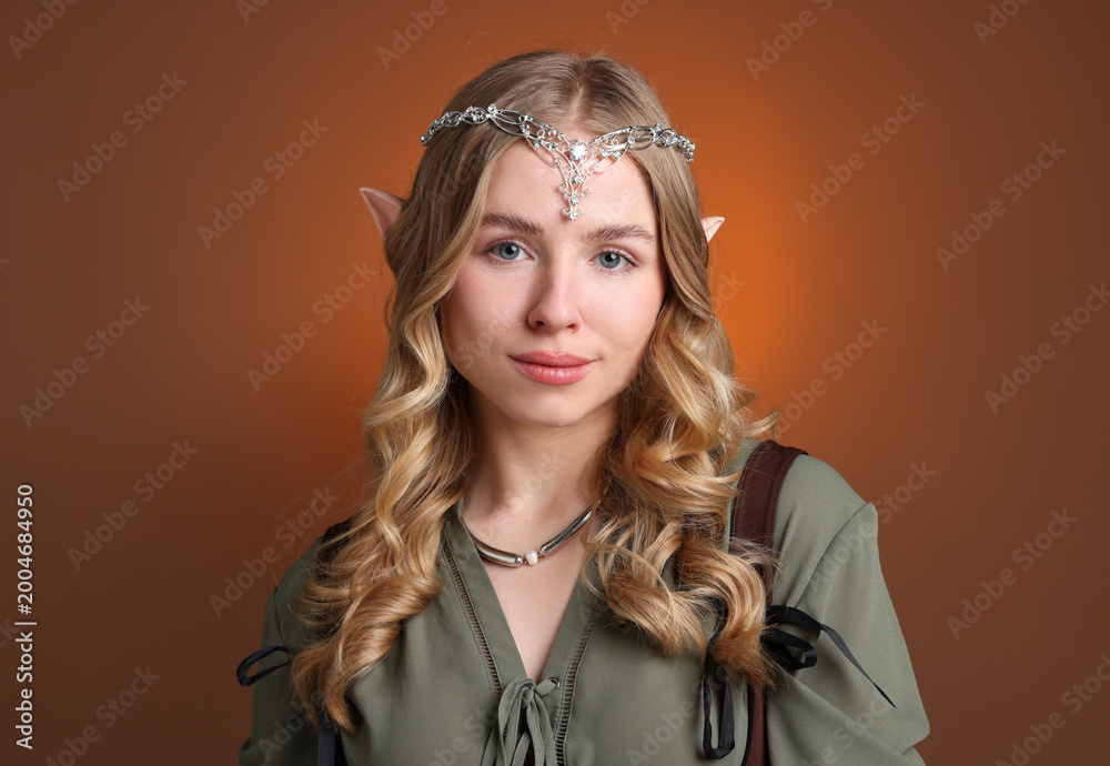 Naklejka premium Beautiful girl dressed as elf on brown gradient background