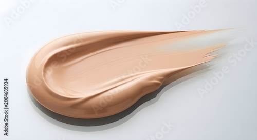 smear of beige foundation makeup on white background
