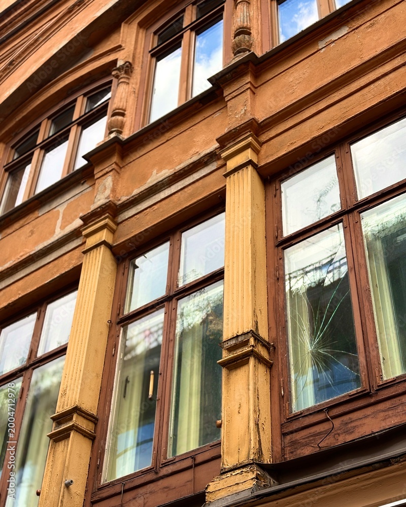 Obraz premium Weathered Vintage European Building Facade with Ornate Windows