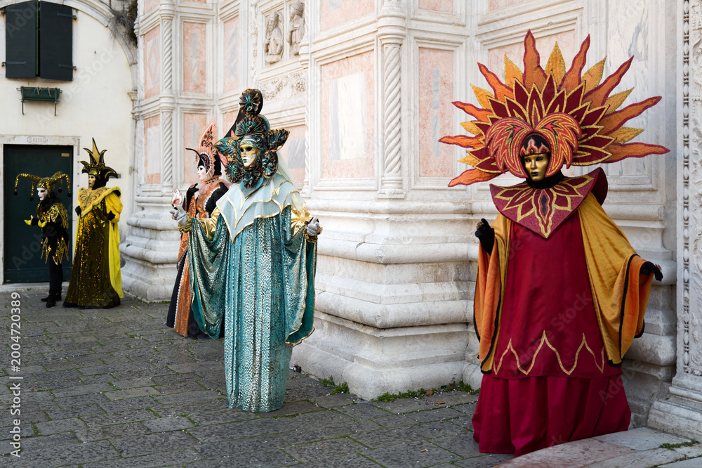Naklejka premium Venice, Italy - February 17, 2026 - People dressed in masks for the Venice Carnival have their photos taken by tourists