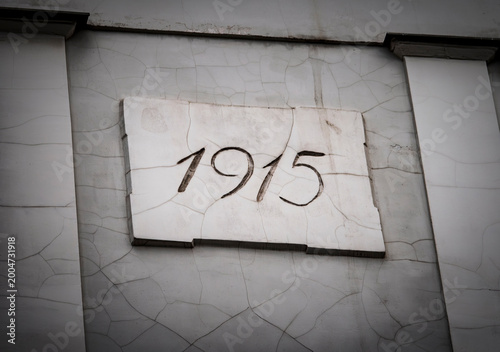 Handwritten date '1915' on a distressed white wall