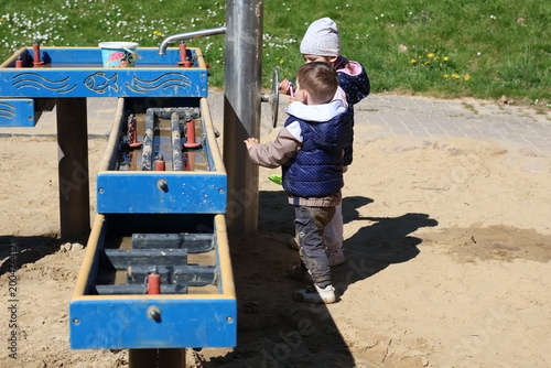 Εκτύπωση καμβά Two adorable toddlers playing together in a sandbox at a playground on a sunny day