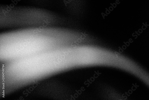 Grayscale abstract glowing light swoosh over black grainy background