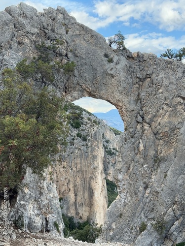 Spectacular rock arch Arcu ‘e su tasaru on the trail to Cala Mariolu beach, Gulf of Orosei, Sardinia, Italy