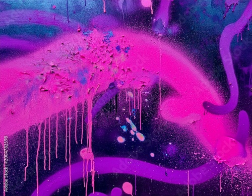 close up graffiti on a wall features neon pink and purple spray paint paint splatter and abstract shapes representing urban street art