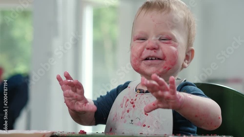 Cute messy little baby joyfully looks at camera, creating a colorful and delightful mess while playing and learning, highlighting the simple and pure joys of early childhood