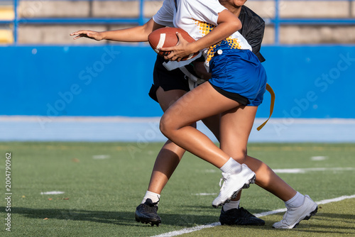 Tableau sur toile Female flag football player running with the ball during a fast-paced game