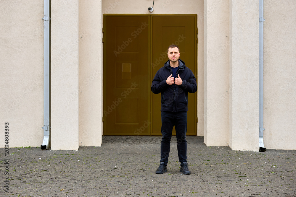 Fototapeta premium Man stands confidently in front of a sturdy, golden door