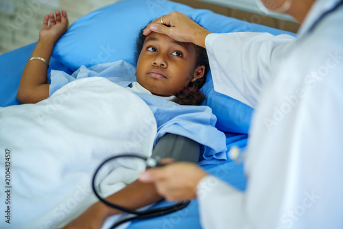 Doctor child patient hospital bed healthcare wellness pediatric checkup fever as caring doctor touches forehead offering gentle support and therpy toward recovery and calm