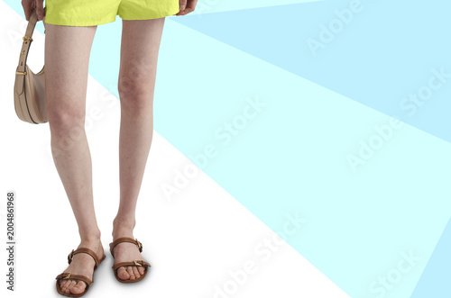 Bright summer outfit with yellow shorts, sandals and handbag on pastel geometric background