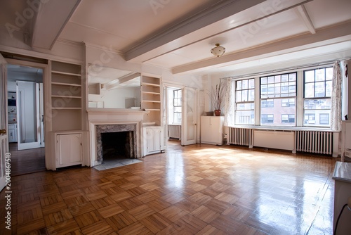 Empty room with white walls, fireplace, and built-in shelves