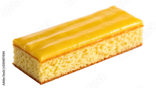 Single rectangular slice of lemon drizzle sponge cake with yellow glaze on white background