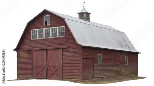 Traditional red wooden barn with a metal roof and cupola isolated on a plain white background