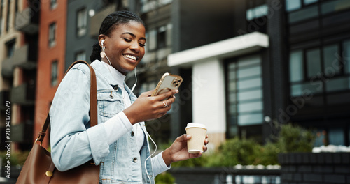 Konstfotografi Phone, walking and black woman in city with earphones for music, internet and coffee on morning commute