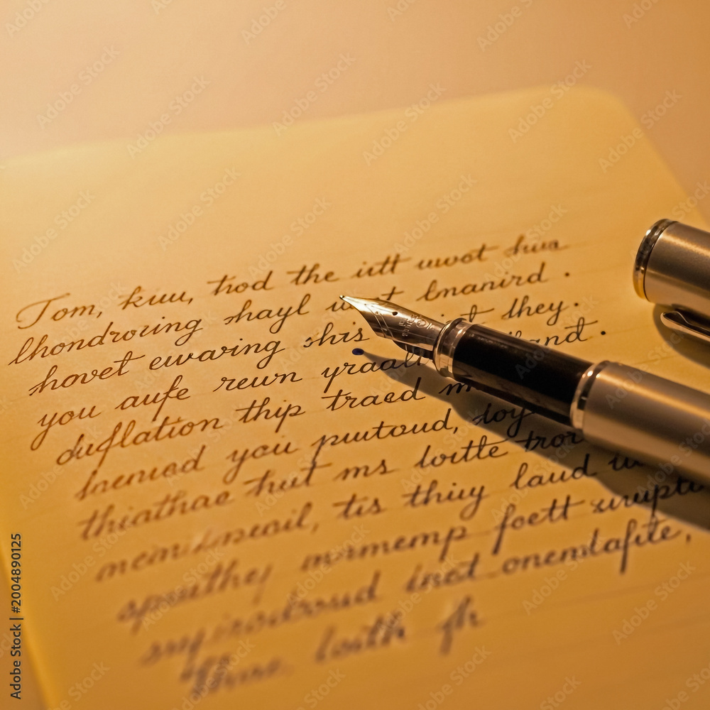 Fototapeta premium Closeup of a fountain pen writing on a yellow piece of paper with handwritten text