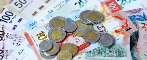 Mexican peso money bills and coins on table. Mexico cash of MXN currency close up