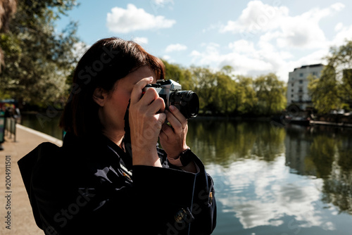 Obraz na plátne Woman photographer capturing outdoor urban landscape with camera