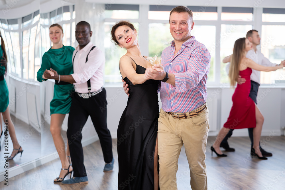 Fototapeta premium Elegant couples dancing tango, enjoying dance moves in dance salon