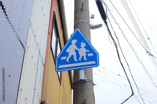 Japanese Blue Road Sign Indicating School Zone and Pedestrian Crossing
