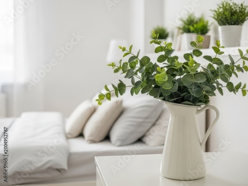 Serene white bedroom with eucalyptus plant in white vase on coffee table