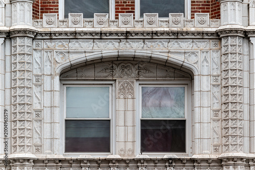 Two rectangular windows beneath a single arch on a brick wall clad in decorative tiles, with two columns on either side. From the Windows of the world series.
