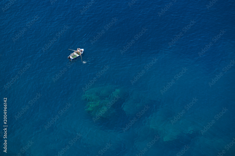 Obraz premium Minimal Blue Ocean Background with Small Boat and Copy Space