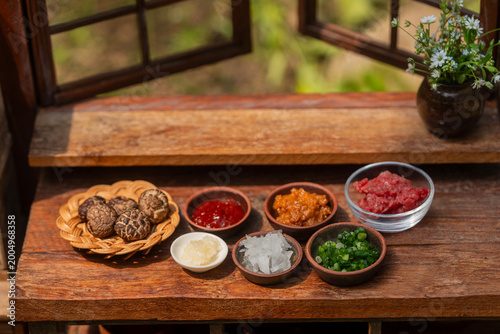 Various fresh cooking ingredients and sauces neatly arranged on a rustic wooden