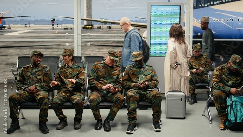 Schilderij op canvas Chatting, going home and multiethnic army soldiers sitting on airport lounge chairs