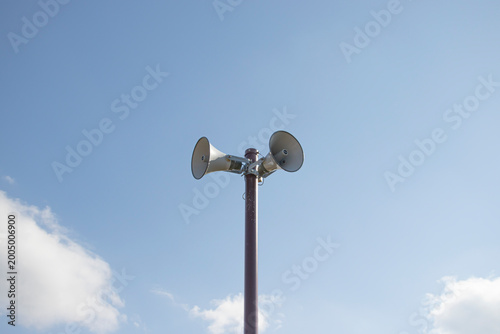 Фотография Communication horn speakers on pole under clear blue sky