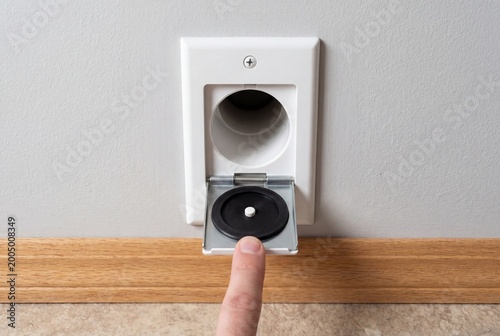 Finger opening a central vacuum wall inlet