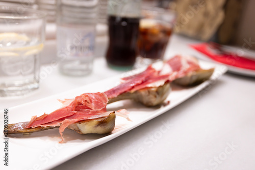 Black Iberian pig on Artichoke at the dish in Spanish tapas