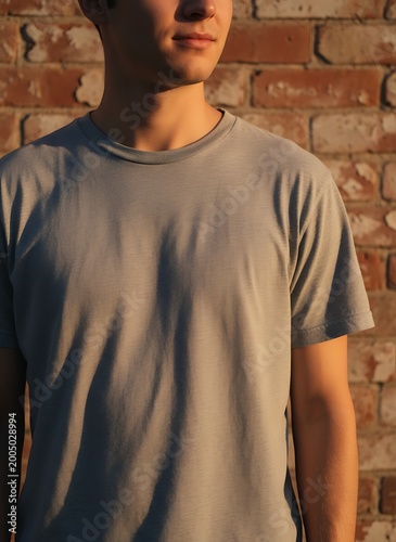 Warm Sunlit Grey T Shirt Mockup on Male Model Against Rustic Brick Wall for Casual Fashion Branding