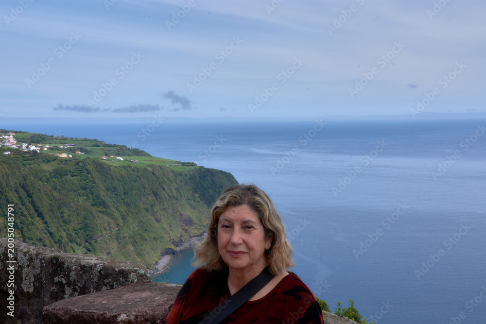 Fototapeta premium Beautiful woman enjoying scenic views at the iconic Miradouro da Ponta Madrugada, Azores.
