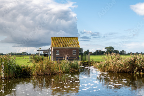 Small electric pumping station used for polder drainage along Wijde Wijmerts waterway, Friesland, Netherlands