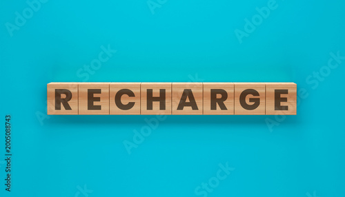 Φωτογραφία Recharge: A vibrant image of the word Recharge spelled out on wooden blocks, suggesting a sense of renewal and revitalization