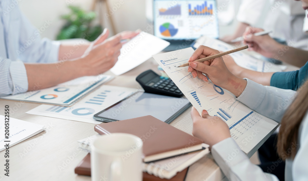 Obraz premium Business team analyzing financial reports and charts in office meeting.