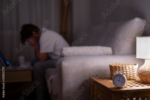 Bild auf Leinwand Exhausted woman struggling with sleep deprivation and stress, sitting in a dark