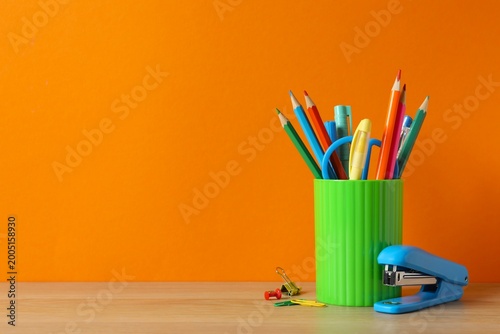 Tableau sur toile Pencil holder with school supplies on wooden table, space for text