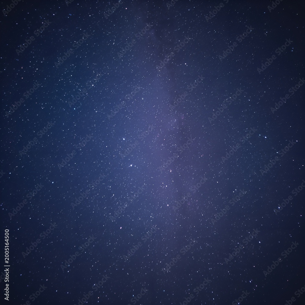 Fototapeta premium Beautiful starry night sky with countless stars and visible Milky Way galaxy. Deep blue cosmic background with long exposure effect, creating a calm, dreamy, and infinite universe atmosphere