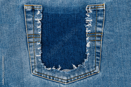 Tableau sur toile Ripped denim fabric showing a pocket area with frayed edges in a casual style