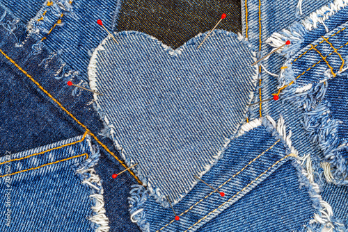 Konstfotografi Crafting a heart from denim pieces using pins on a fabric surface during a sewin