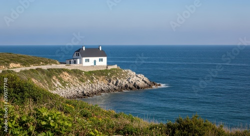 Secluded white house perched on a cliff by the sea