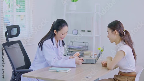 The dentist is talking to the patient and showing them a model of the teeth. (Concept of dental care)