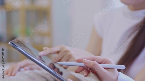  A doctor or nurse is talking to a patient sitting on a sofa in a private hospital room.