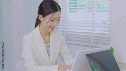 Asia beautiful business woman working with laptop in living room at office