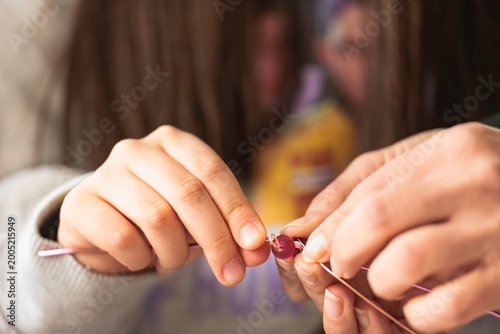 Children gather in a lively workshop filled with colorful beads and tools, learning to create their own handmade jewelry while exploring their artistic talents and imagination