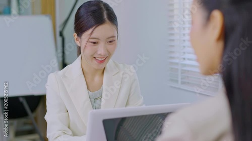 Smiling Asian businesswoman professional marketing manager typing on laptop and sitting in office