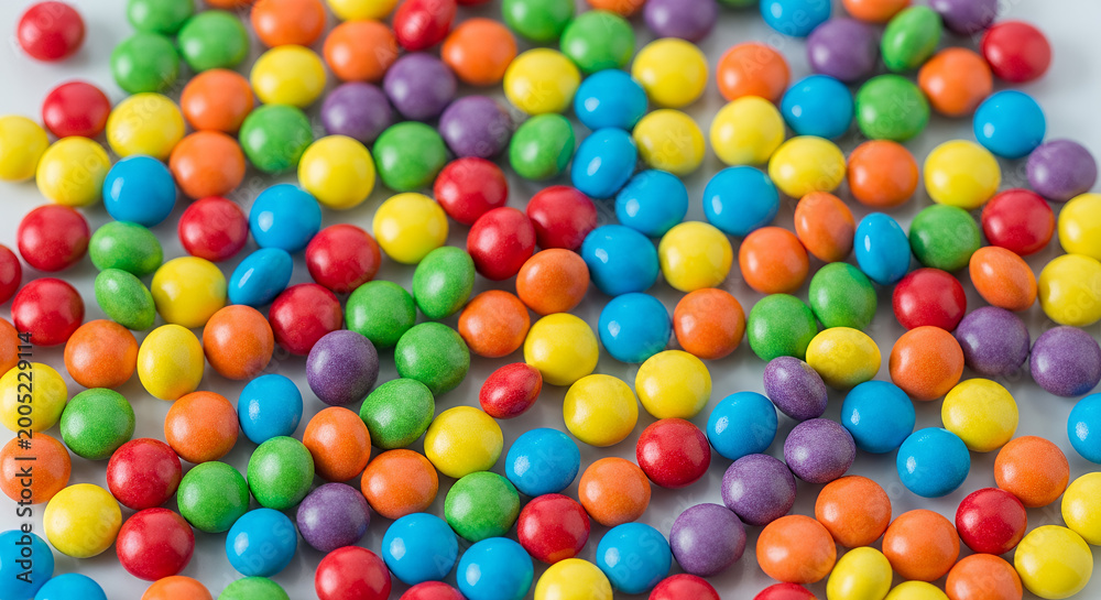 Fototapeta premium Colorful round candies background with vibrant colors, copy space